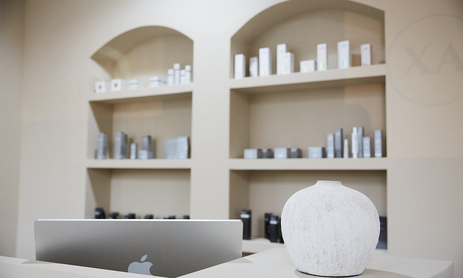 Empfangstresen mit Laptop, dekorativer Keramikvase und BABOR-Produktregal im Kosmetikinstitut XA laser|cosmetics in Koblenz